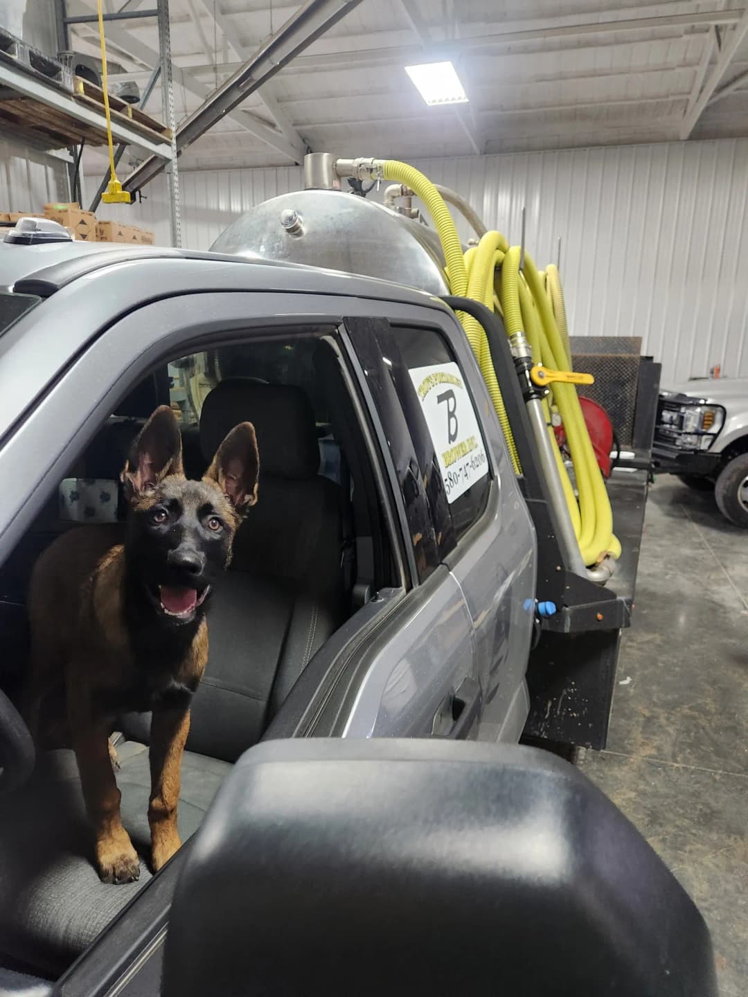 The Brower Inc. company dog riding in a service truck