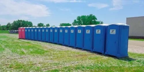 Row of freshly serviced Brower Inc. portable restrooms lined up and ready for outdoor event delivery in Oklahoma