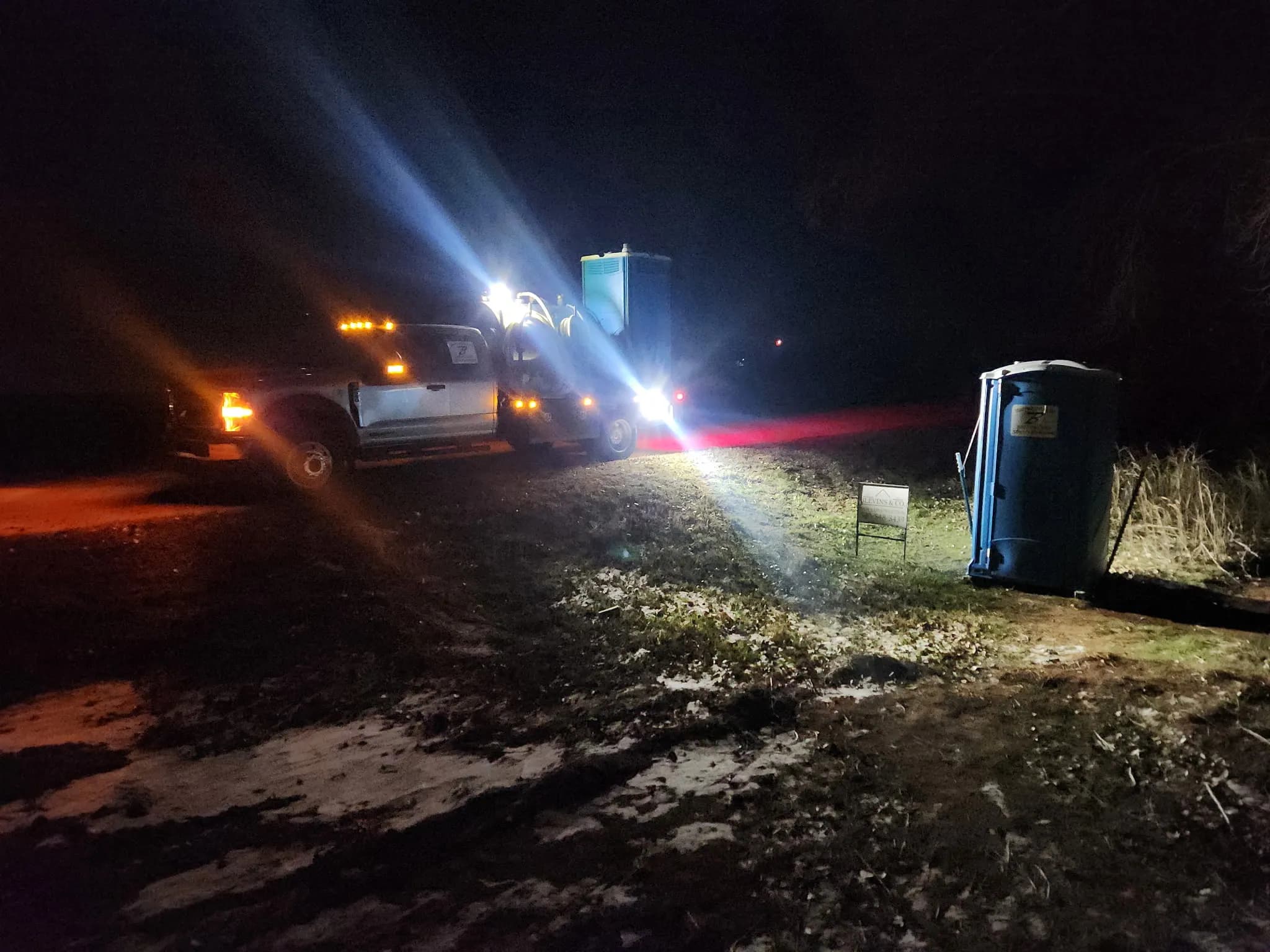 Brower Inc. service truck placing a portable restroom at night