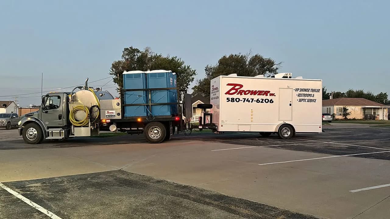 Brower Inc. service truck hauling portable restrooms and towing a VIP shower trailer
