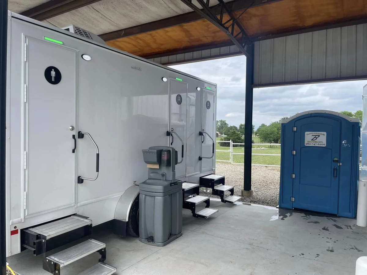 Brower Inc. hand washing station set beside a restroom trailer and a standard portable restroom